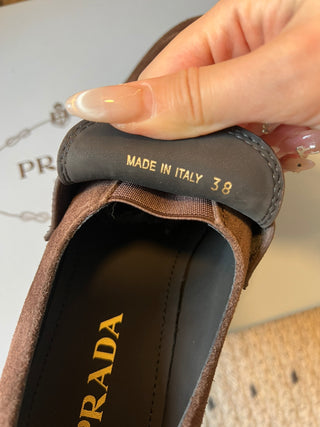 Prad classic loafers with triangular logo and serrated design.