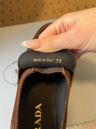 Prad classic loafers with triangular logo and serrated design.