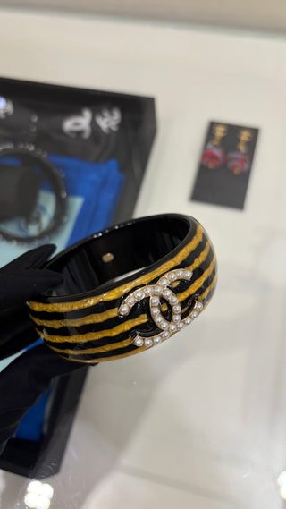 𝑪𝒉𝒂𝒏𝒆 * Vintage-style pearl and double-C stripe acrylic bracelet.
