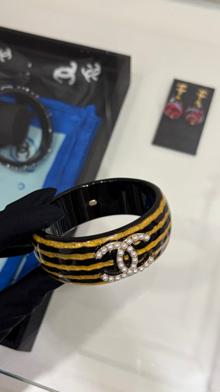 𝑪𝒉𝒂𝒏𝒆 * Vintage-style pearl and double-C stripe acrylic bracelet.